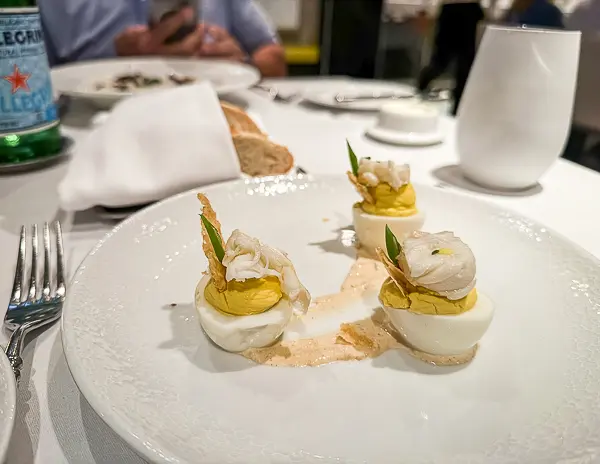 A creative twist on deviled eggs, topped with chunks of lobster and a touch of seasoning, served as an appetizer at The Haven restaurant on Norwegian Getaway.