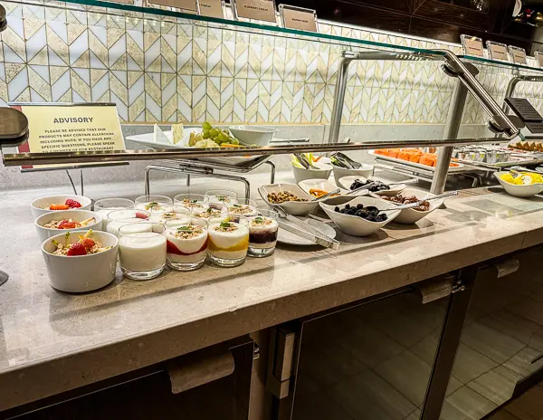 Self-service breakfast station at The Haven restaurant on the Norwegian Getaway, featuring an array of yogurts, parfaits, fresh fruits, and toppings