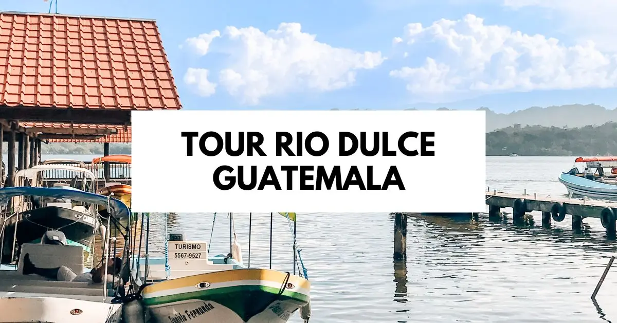 featured blog image shows boats docked along the Rio Dulce in Guatemala, with a red-roofed structure and a sign that reads "Tour Rio Dulce Guatemala" prominently displayed.