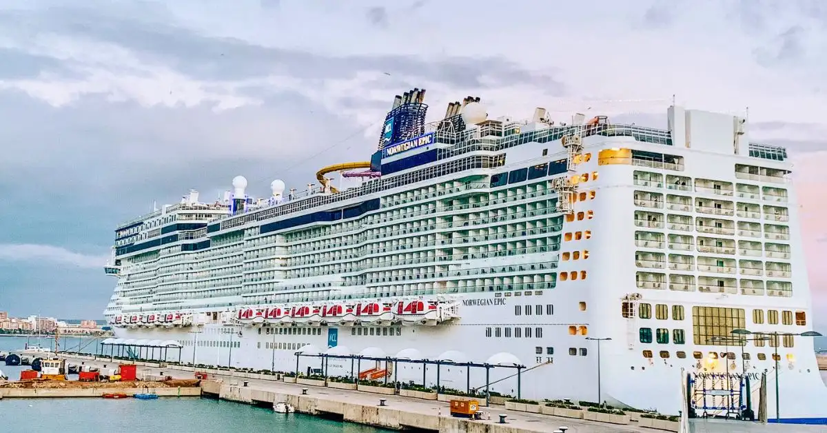 Featured image of the Norwegian Epic cruise ship docked at port under a pastel sky, perfect for a Norwegian Epic review highlighting what we loved and hated about the ship.