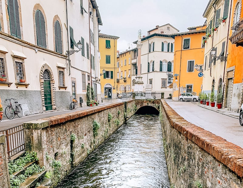 Small canal running through a quiet area of historic Lucca, Italy