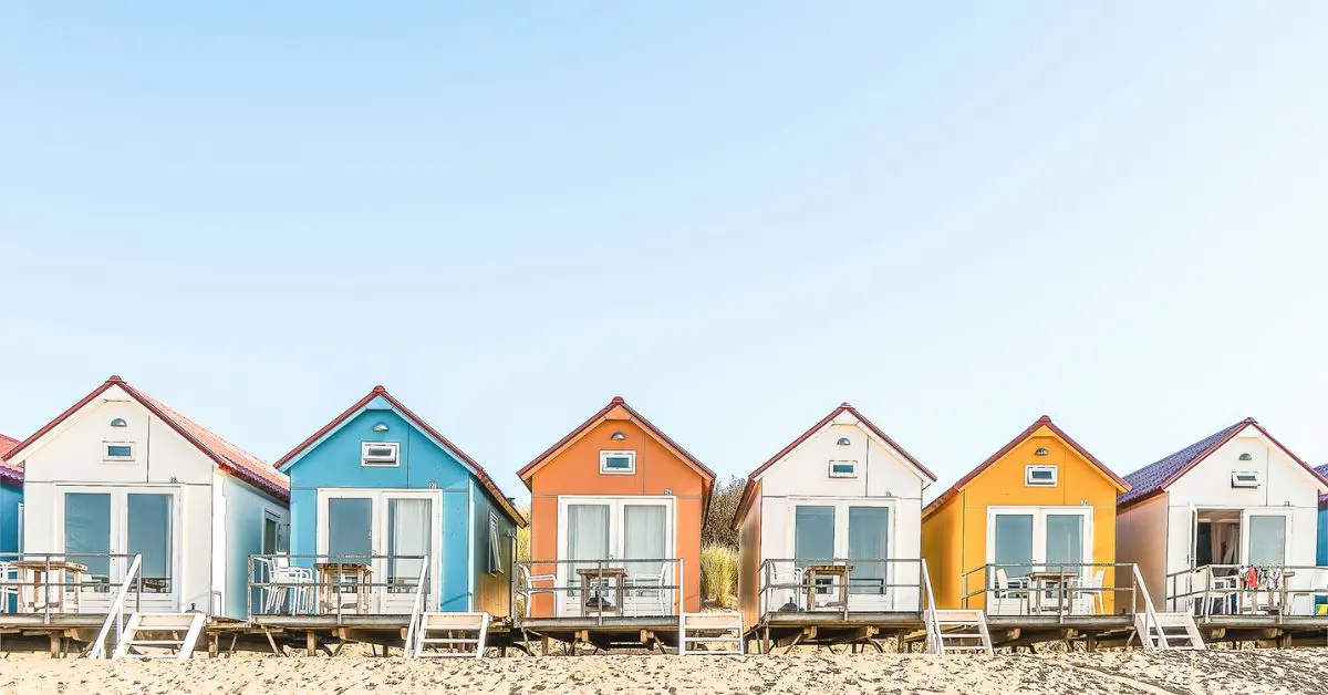 Featured image of colorful beachfront cabins representing Airbnb tips for guests.