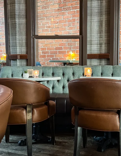Cozy booth seating with tufted backs, leather chairs, and lit candles, creating an intimate atmosphere at magnolia in pasadena california