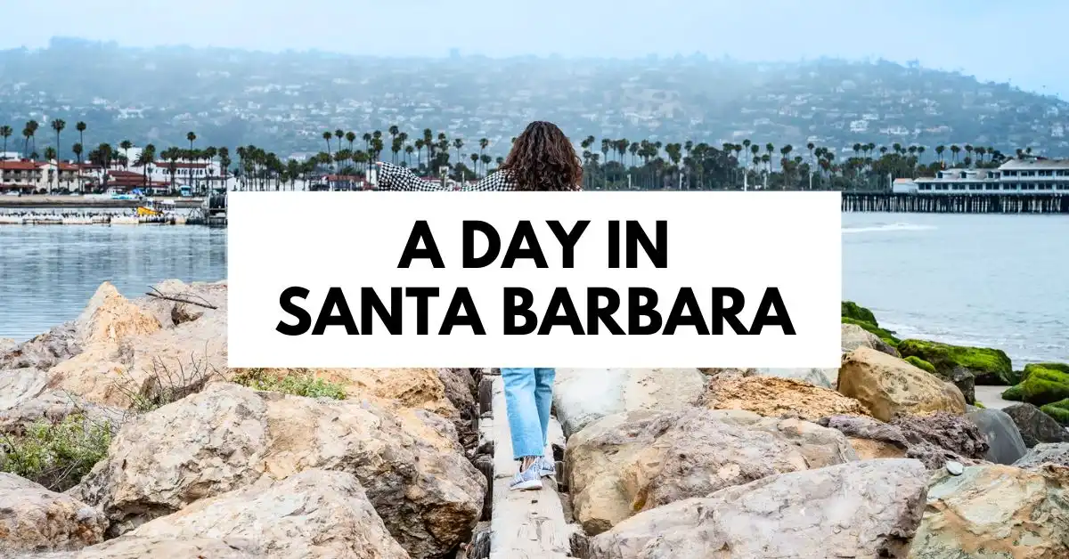 featured blog image of kathy walking on a rocky path towards Santa Barbara Pier with the text 'a day in santa barbara' overlaying a scenic coastal background