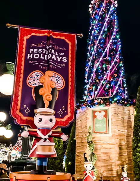 he facade of It's a Small World at Disneyland lit up with colorful holiday lights, creating a magical Christmas display.