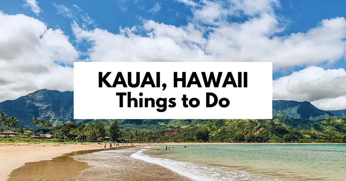 featured blog image: Kauai, Hawaii beach scene with lush green mountains, blue skies, and white clouds, featuring text overlay that reads 'Kauai, Hawaii Things to Do.'