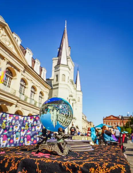 Crystal ball on a tarot reader's table in Jackson Square, with St. Louis Cathedral in the background.