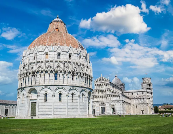 Piazza dei Miracoli in Pisa, featuring the iconic Leaning Tower, the Cathedral, and the Baptistery under a clear blue sky.