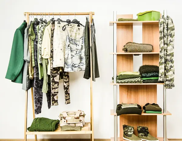 Clothing rack and shelves displaying various camouflage print garments and accessories.