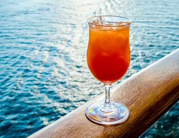 fruity drink on cruise railing by the sea