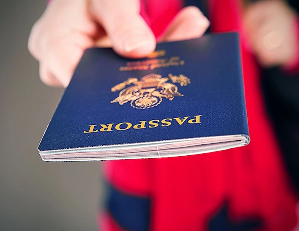 female hand handing over passport