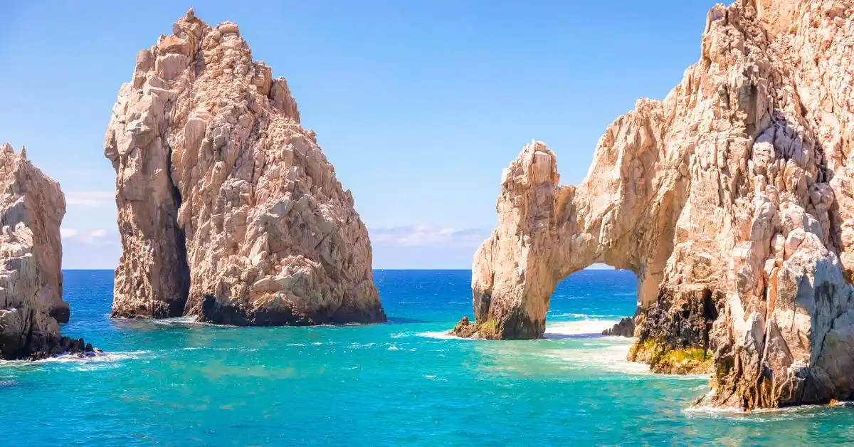 featured blog image without text of the iconic El Arco, a natural archway formed in a large rock formation, situated at Land’s End in Cabo San Lucas. The turquoise waters of the Pacific Ocean surround the arch, highlighting its majestic and scenic beauty under a clear blue sky.