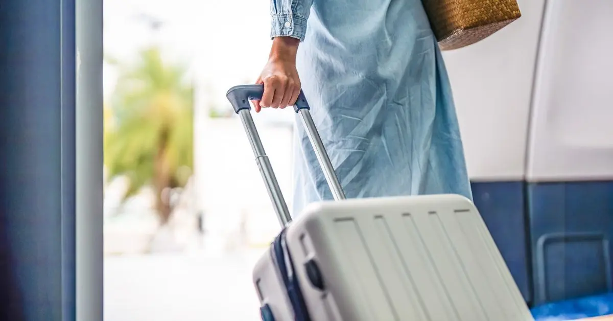 featured image: Person pulling a rolling suitcase while traveling, representing practical travel tips for beginners.