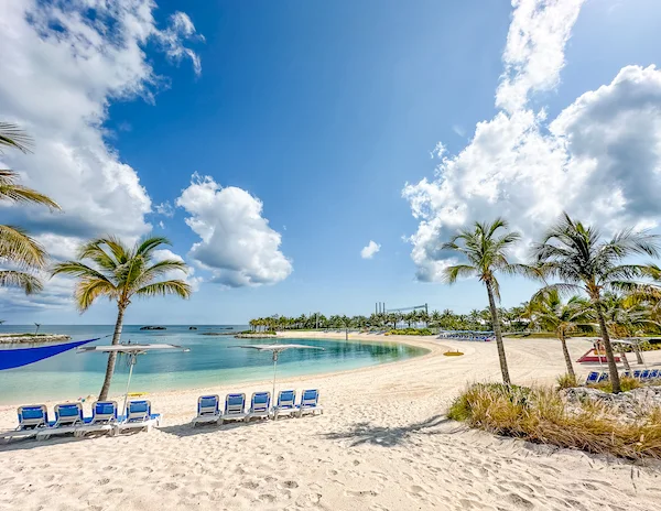 Palm trees and lounge chairs on the beach, overlooking the Silver Cove lagoon at Great Stirrup Cay