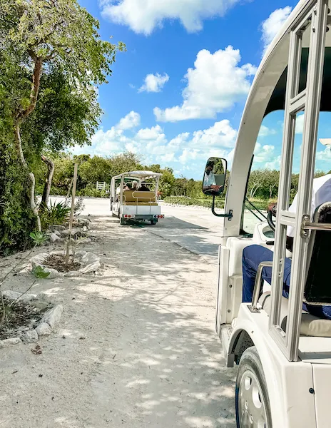 Golf carts driving on a sandy path at Great Stirrup Cay to Silver Cove.