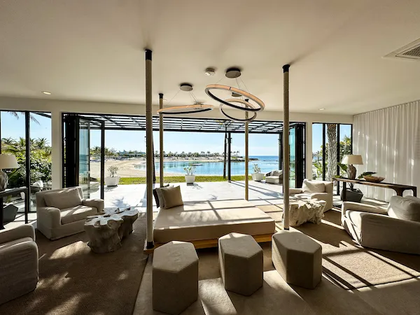 Interior of Great Stirrup Cay Silver Cove reception modern furniture, large windows, and a view of a lagoon.