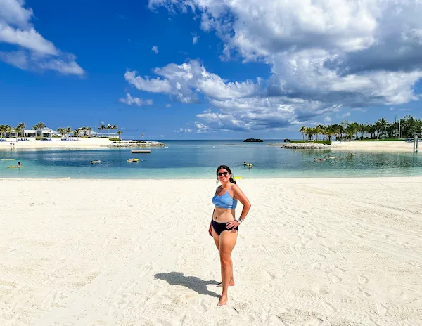 kathy standing on the beach in front of the Silver Cove lagoon at Great Stirrup Cay.