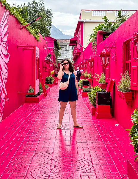 Woman (kathy) posing on Pink Street, an alleyway painted dark pink in Puerto Plata.