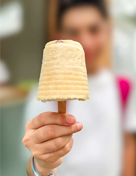 Hand holding a homemade ice cream popsicle from Natural Ice Cream on Umbrella Street in Puerto Plata.