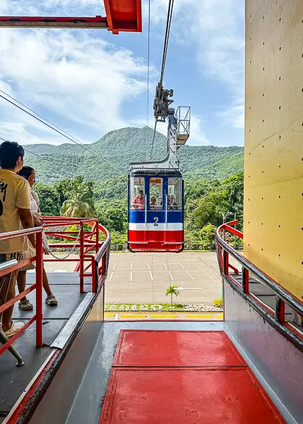 Puerto Plata cable car arriving at the station with people waiting to board.