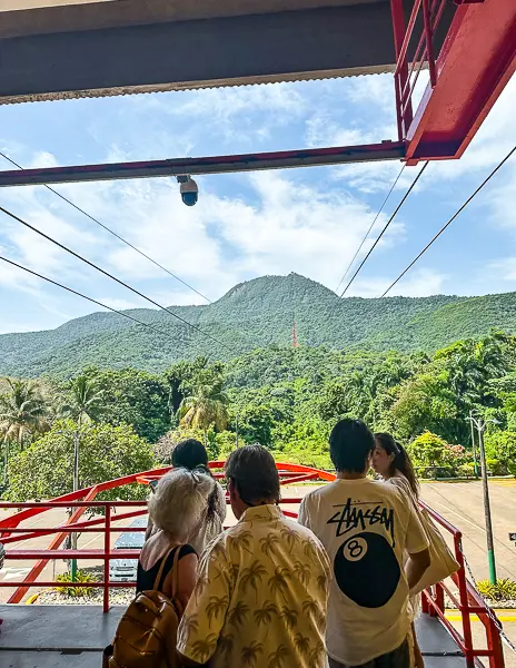 People waiting for the Puerto Plata cable car with a view of the mountains in the background.