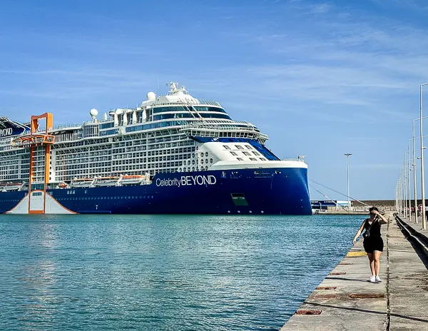 Celebrity Beyond cruise ship docked at a port with a person  (kathy) walking along the pier.