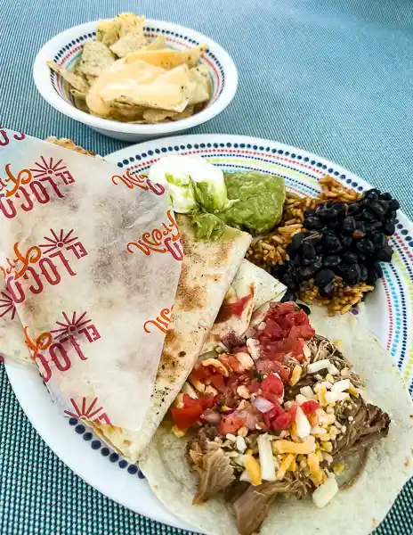 Quesadilla and shredded beef taco with toppings from El Loco Fresh on Utopia of the Seas, served with rice, black beans, guacamole, and a side of nachos with cheese.