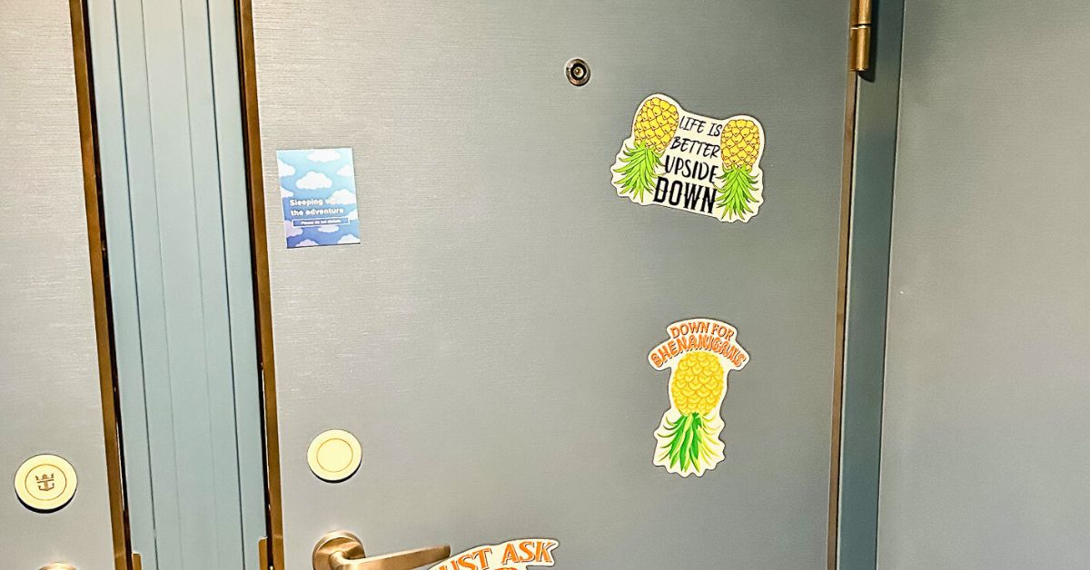 Cruise stateroom door decorated with upside-down pineapple stickers, sparking discussion around Carnival’s guidelines for appropriate decorations.