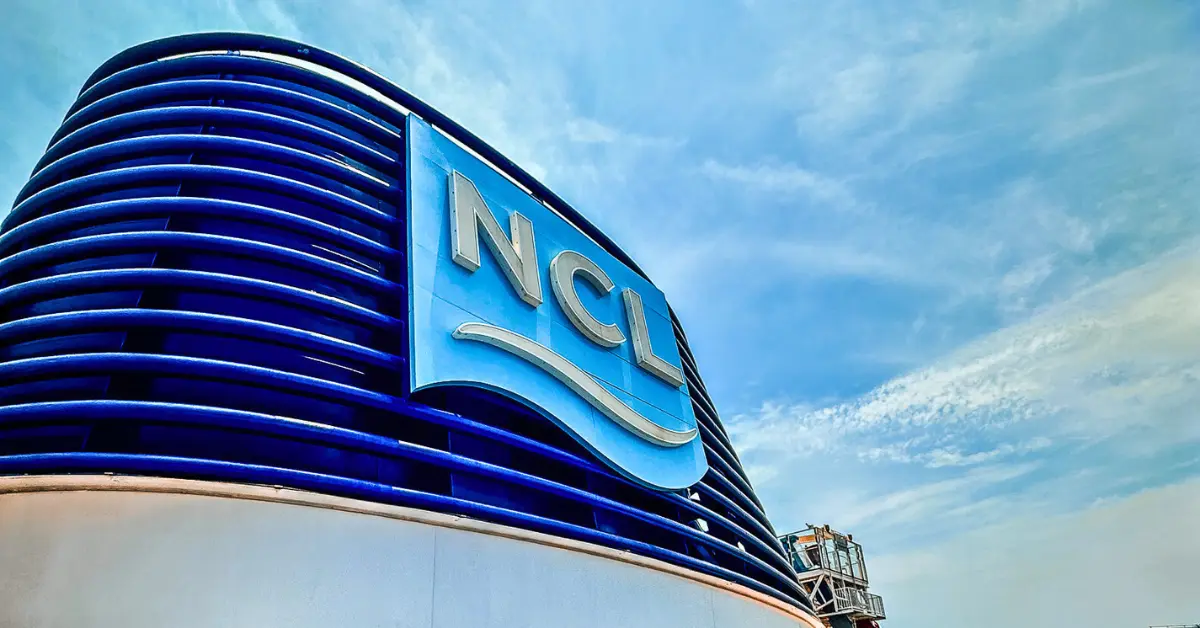 Norwegian Cruise Line (NCL) logo against a bright blue sky, symbolizing the cruise line's commitment to innovation and luxury experiences.