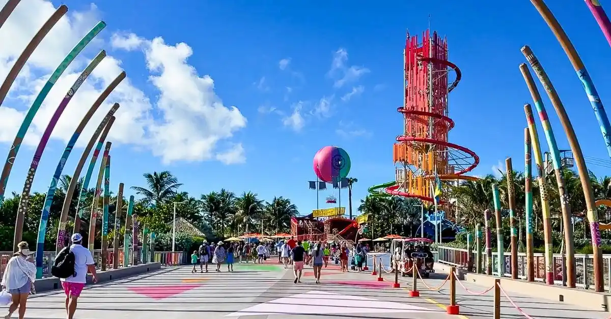 Featured image: Entrance to CocoCay with colorful archways, people walking, and a tall red water slide in the background, showcasing what to do for free at CocoCay, Royal Caribbean’s private island.