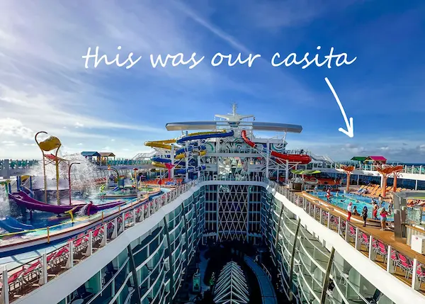 View of the pool deck on Royal Caribbean’s Utopia of the Seas with an arrow pointing to a casita and text that reads 'this was our casita,' highlighting its location near the pool and water slides.