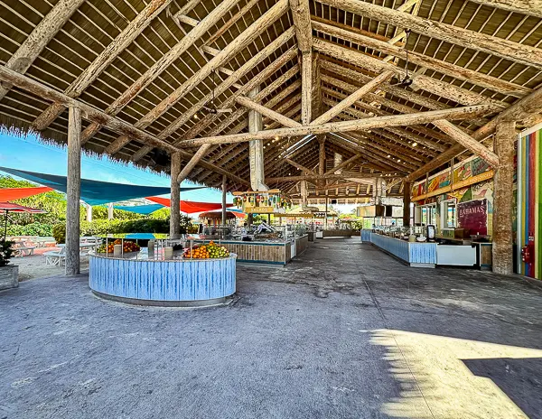 Skipper’s Grill at CocoCay, an open-air BBQ buffet area with wooden beams, food stations, and shaded outdoor seating.