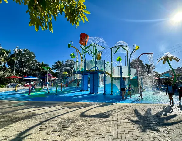 Splashaway Bay at CocoCay, a colorful kids’ waterpark featuring water cannons, slides, and a tipping water bucket under a sunny blue sky.