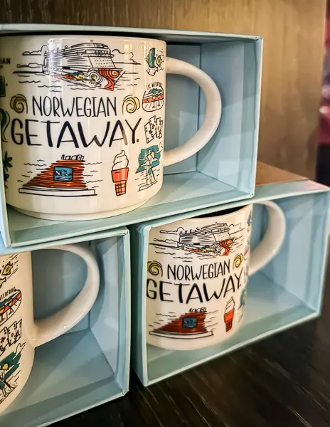 Three boxed Norwegian Getaway-themed Starbucks mugs with colorful cruise ship-inspired designs.