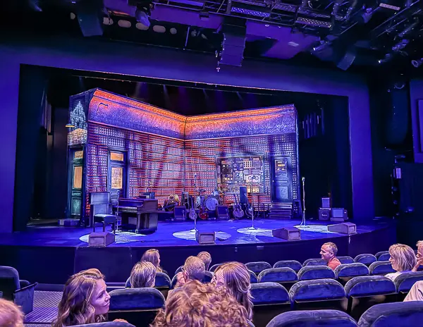 Stage setup for the "Million Dollar Quartet" show on the Norwegian Getaway, featuring a Sun Records-inspired set with musical instruments, vintage decor, and seating filled with eager audience members.