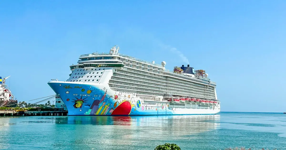 A Norwegian Cruise Line ship docked at a sunny port, symbolizing recent NCL changes impacting the cruising experience.