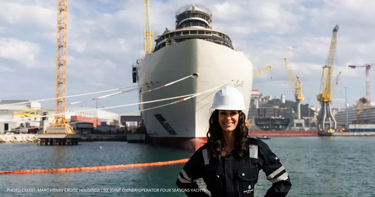 Captain Kate McCue standing in front of the first Four Seasons Yacht under construction, wearing a hard hat and a work uniform. Photo credit: Marc-Henry Cruise Holdings Ltd, Joint Owner/Operator Four Seasons Yachts. McCue made history as the first American woman to captain a major cruise ship and became a fan favorite during her time with Celebrity, most recently leading Celebrity Beyond. Now, she’s shifting from large ocean liners to a smaller, high-end yachting experience with Four Seasons Yachts. Their first ship will have 95 suites, a nearly one-to-one guest-to-crew ratio, and suite sizes starting at 581 square feet—the largest in the industry. Four Seasons Yachts, a partnership with Marc-Henry Cruise Holdings, is bringing the luxury hotel brand to the water with a focus on exclusive experiences, spacious accommodations, and personalized service. The yacht will feature a 65-foot-long aft pool deck and a unique “Funicular” connecting different decks. This move comes after McCue announced her [departure from Celebrity Cruises](INSERT LINK), and now she’s set to bring her leadership to a brand-new venture in the cruise industry. For more details, visit Four Seasons’ official announcement.