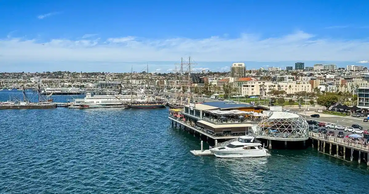 San Diego's waterfront (view from cruise ship) featuring historic ships, a modern dining pier, and a vibrant harbor, set to welcome Royal Caribbean as a new homeport in 2026.